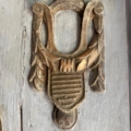 Un ornement en bois sculpté, dont la silhouette rappelle celle d'une lyre et orné de drapés, met en valeur la surface grise patinée de ce miroir trumeau du XIXe siècle, évoquant ainsi le décor classique de cette époque. Brocante 93