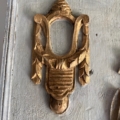 Orné d'une sculpture raffinée de couleur dorée représentant un scarabée, cet élégant détail embellit la surface en bois gris du trumeau « Miroir » du XIXe siècle. Brocante 93