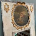 Miroir trumeau du XIXe siècle, doté d'un cadre ancien richement décoré avec des touches de feuille d'or, d'un tableau circulaire représentant deux personnages et d'un miroir trumeau en dessous. Brocante 93