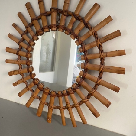 Le « Miroir soleil bambou 1950 » se distingue par son cadre décoratif en bambou, orné de deux rangées de tiges de bambou disposées selon un motif rayonnant saisissant, qui incarne à la perfection l'élégance intemporelle d'un miroir soleil classique des années 1950. Brocante 93