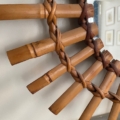 Gros plan sur le « Miroir soleil bambou 1950 », mettant en valeur son cadre en bambou tressé aux lattes diagonales se détachant sur un mur clair — élément d’un design circulaire inspiré de l’élégance de la décoration des années 1950. Brocante 93