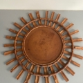 Le « Miroir soleil bambou 1950 », un miroir mural circulaire en bambou de style « sunburst » aux rayons rayonnants, est accroché à un mur bicolore. Brocante 93