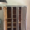 Le « Vestiaire en bois 1940 », une armoire vintage en bois dotée de quatre portes qui, une fois ouvertes, dévoilent des étagères vides, trône avec élégance sur un parquet. Brocante 93