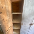 Le « Vestiaire en bois 1940 » est une armoire ouverte en bois dotée de cinq étagères, qui rappelle le style d’un vestiaire en bois classique des années 1940. Ce meuble vintage présente des étagères ornées de subtiles traces d’écriture ou de taches, qui rehaussent son caractère unique et son charme. Brocante 93