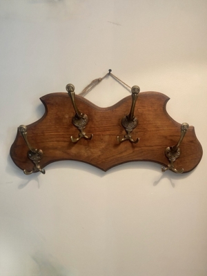 Un « Porte-serviettes 1960 », un porte-manteau vintage en bois muni de cinq crochets en laiton ouvragés, est accroché à un mur blanc. Brocante 93