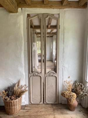 Portes d’ascenseur de 1940 : portes d’ascenseur anciennes en bois, ornées de panneaux miroirs, entre des murs blancs. Brocante 93