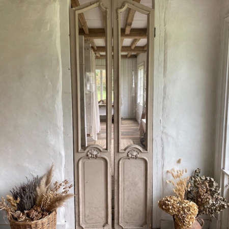 Portes d’ascenseur de 1940 : portes d’ascenseur anciennes en bois, ornées de panneaux miroirs, entre des murs blancs. Brocante 93