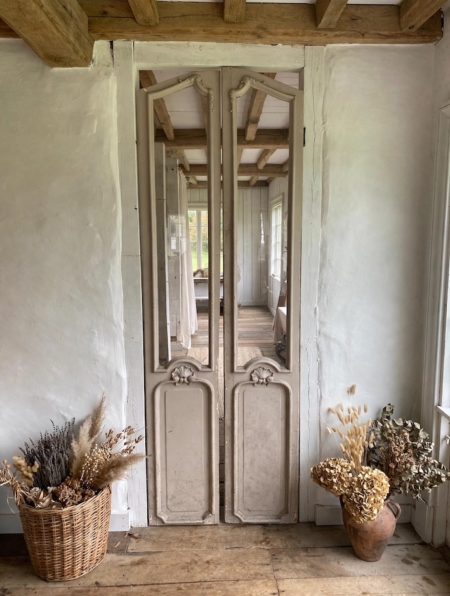 Portes d’ascenseur de 1940 : portes d’ascenseur anciennes en bois, ornées de panneaux miroirs, entre des murs blancs. Brocante 93
