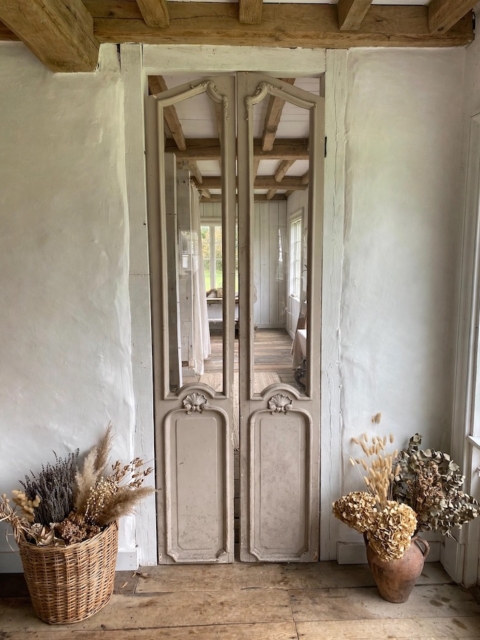 Portes d’ascenseur de 1940 : portes d’ascenseur anciennes en bois, ornées de panneaux miroirs, entre des murs blancs. Brocante 93