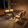 Table à manger ovale en verre des années 1970, accompagnée de quatre chaises crème texturées et de trois suspensions. Brocante 93