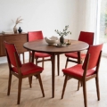 Table à manger ronde en bois, accompagnée de quatre chaises vintage « Chaises skai » des années 1960. Brocante 93