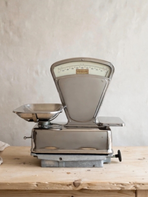 Balance de commerçant de 1950, équipée d'un cadran de mesure, posée sur une table en bois. Brocante 93