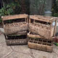 Quatre caisses de brasserie vintage en bois datant de 1950, empilées sur une terrasse. Brocante 93
