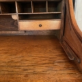 Intérieur d'un bureau américain à cylindre datant de 1930, doté d'étagères ouvertes et d'un petit tiroir. Brocante 93