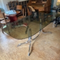 Table à manger des années 1970 avec un plateau en verre fumé et un piètement chromé incurvé. Brocante 93