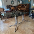 Table à manger des années 1970 avec un plateau en verre fumé et un piètement chromé incurvé. Brocante 93