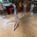 Table à manger des années 1970 avec un plateau en verre fumé et des pieds chromés incurvés. Brocante 93