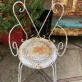 Chaises en fer forgé des années 1950 : une chaise vintage en métal blanc, dotée d'un dossier à volutes et d'une assise ajourée. Brocante 93