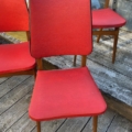 Trois chaises longues rouges vintage « Skai » des années 1960, avec des pieds en bois, disposées sur une terrasse en bois. Brocante 93