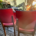 Deux chaises vintage « Skai » des années 1960, avec assise et dossier rouges, disposées sur une terrasse en bois. Brocante 93