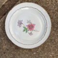 Assiettes plates vintage de 1950, en céramique blanche, ornées d'un motif floral et d'une bordure dorée. Brocante 93