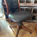 Fauteuil de bureau américain des années 1930 : fauteuil pivotant vintage en bois avec assise rembourrée de couleur foncée. Brocante 93