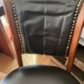 Fauteuil de bureau américain des années 1930, avec une assise rembourrée noire et des clous décoratifs en laiton. Brocante 93