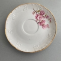 Tasses à café des années 1960 : soucoupe vintage blanche à bord doré, ornée de volutes en relief et d'un motif floral rose. Brocante 93