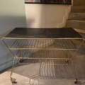 Table basse des années 1950, dotée d'une tablette supérieure perforée et de deux tablettes inférieures en fil métallique. Brocante 93