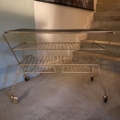 Table basse des années 1950, chariot à roulettes en métal, avec deux étagères en fil métallique et un plateau noir. Brocante 93
