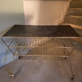 Table basse des années 1950 : un chariot vintage en métal doré, doté d'un plateau supérieur noir perforé. Brocante 93